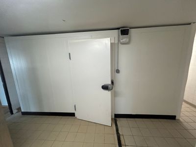 une porte blanche dans une pièce au sol carrelé