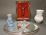 un plateau en argent sur lequel repose un crucifix, à côté de deux vases et d'un miroir