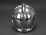 a shiny silver helmet on a black surface