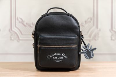 a small black backpack with a bird on it sitting on top of a table