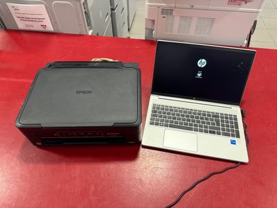 laptop and printer sitting on a red table in a store