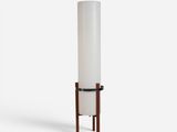 a tall white cylinder lamp with wooden legs and a white cylinder shade