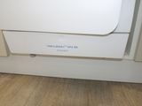 a white dishwasher sitting on the floor in a kitchen