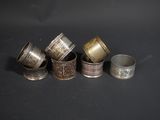 six silver and gold napkins on a black surface