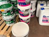 plusieurs seaux de peinture posés sur une palette