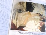 un livre ouvert sur lequel figure l'image d'une femme allongée sur un lit