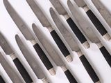 a lot of knives that are lined up on a table