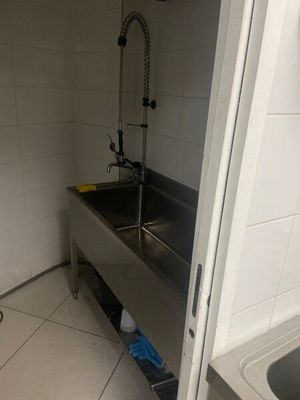 un évier en acier inoxydable dans le coin d'une salle de bains
