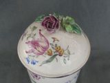 a small container with a flower on it on a table