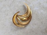 a close up of a gold brooch on a marble surface