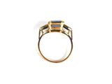 a close up of a gold ring with a blue topaz stone