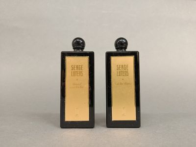 deux flacons de parfum noirs et dorés posés sur une table