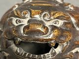 a close up of a metal object with a lion head on it