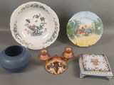 un vase bleu, une assiette et une assiette sur laquelle est représenté un garçon