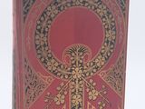 un vieux livre à la couverture rouge ornée de motifs dorés