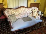 un ours en peluche assis sur un canapé dans un salon