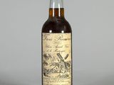 une bouteille de rhum posée sur une table, sur fond gris