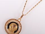 a gold necklace with a black and white image of a woman ' s face