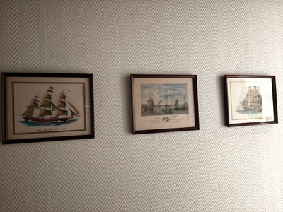 trois tableaux encadrés accrochés au mur du salon