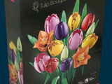 brightly colored tulips in a glass vase in a black box