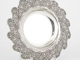 un gros plan sur une assiette en argent ornée d'un motif floral