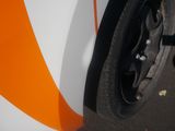 an orange and white car with a black rim