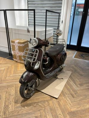 une trottinette posée par terre dans la pièce