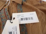 the label is on the shirt that is hanging on the hanger
