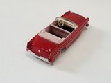a small red toy car on a white surface