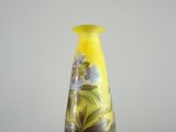 un vase jaune posé sur une table, sur fond blanc