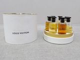 trois bouteilles Louis Vuitton à côté d'un récipient blanc