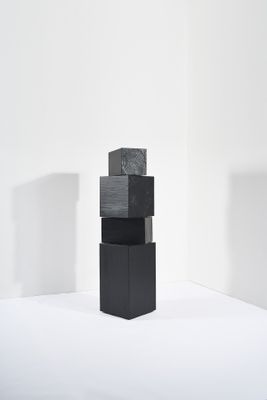une pile de blocs noirs posée sur une surface blanche