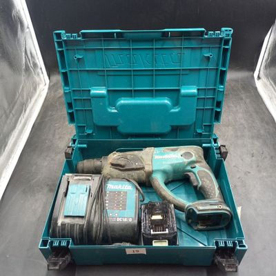 une boîte à outils bleue contenant une perceuse et deux autres outils