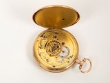a gold pocket watch on a white surface