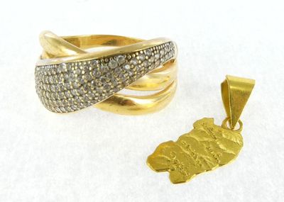 two gold rings and a pendant on a white surface