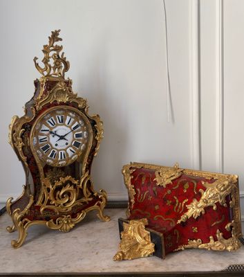 three clocks on a table next to a purse and a clock