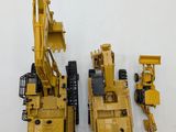 two toy construction vehicles sitting next to each other on a white surface