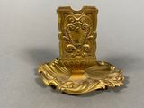 a gold candle holder on a table with a white background