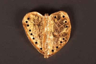 une image représentant un objet doré en forme de cœur sur un fond noir