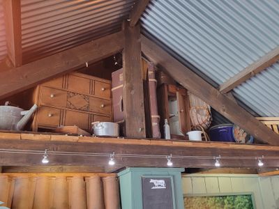 une pièce avec un toit en tôle et une étagère sur laquelle sont posés des casseroles et des poêles