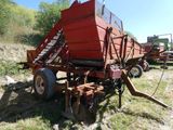 une image représentant un tracteur rouge avec une remorque rouge