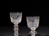 two clear glass goblets sitting on top of a black table