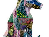 un gros plan sur une sculpture représentant un chien assis sur une surface blanche