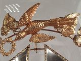 a gold bird on top of a mirror in a room