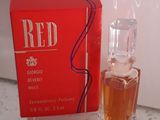 un flacon de parfum posé sur un comptoir à côté d'une boîte rouge
