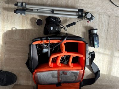 a bag with a camera and a tripod on the floor