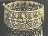 an antique silver bracelet with a design of angels and demons on it