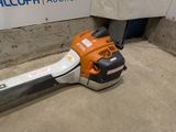 a chainsaw that is laying on the ground next to a wall
