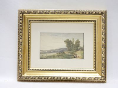 un tableau représentant un paysage, dans un cadre doré, accroché à un mur blanc