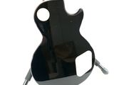 a black electric guitar hanging on a white wall
